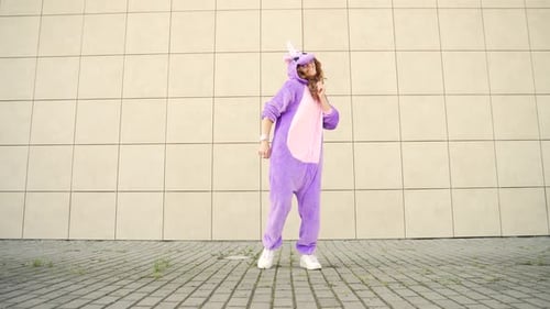 Young Woman Dances in Purple Unicorn Costume