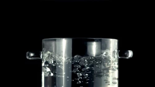 Super Zeitlupe in einer transparenten Pfanne kocht Wasser mit Luftblasen