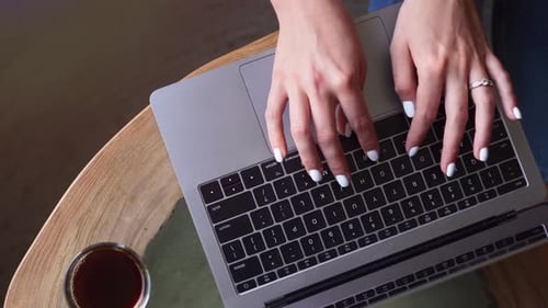 Female Hands Are Typing on the Keyboard