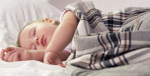 Blonde Baby Sleeping Soundly in Bed