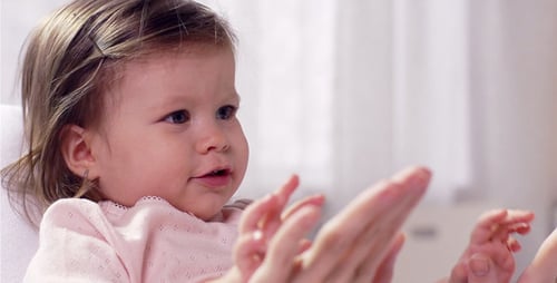 Adorable Infant Clapping Hands with Adult Indoors