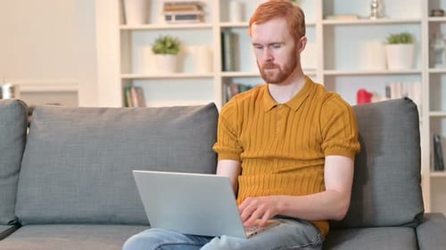 Man Working on Laptop Computer at Home
