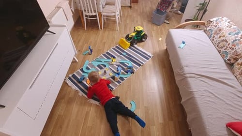Child Playing with Toy Race Track at Home