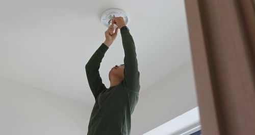 Man Installs New Light Fixture in Home