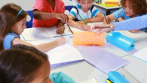 Elementary School Students Write With Teacher in Classroom