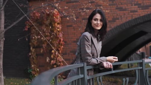 An Attractive Girl of European Appearance Looks at the Camera on the Street.