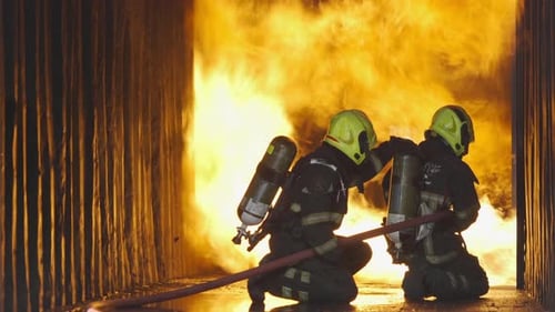Two Firefighters Kneeling Near Fire
