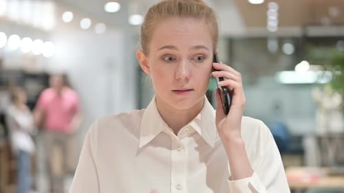 Angry Woman Talking on Phone in Office
