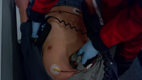 Paramedic Hands Using Defibrillator