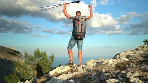 Travel Mountain Hike Back View of Young Guy Hiker Rejoicing and Standing on Rocks By Sea Shore in