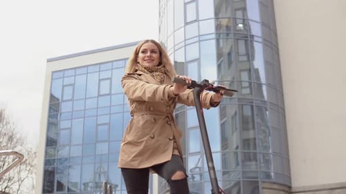 Young Woman Posing with Electric Scooter in City