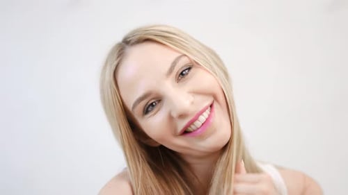 Blonde Woman Smiling and Playing With Her Hair