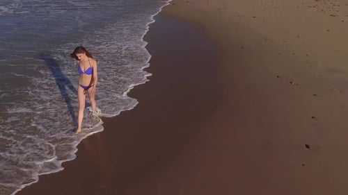 Woman Walking On The Beach