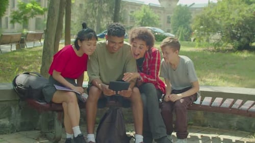 Happy Friends Viewing Tablet Together Outdoors
