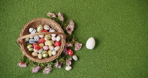 Basket with Many Coloured Eggs on Green Grass Background
