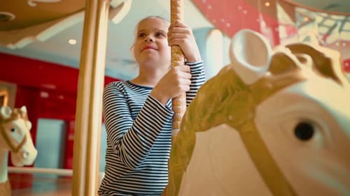 Happy European Blond Teen Smiling While Riding a White Carousel Horse