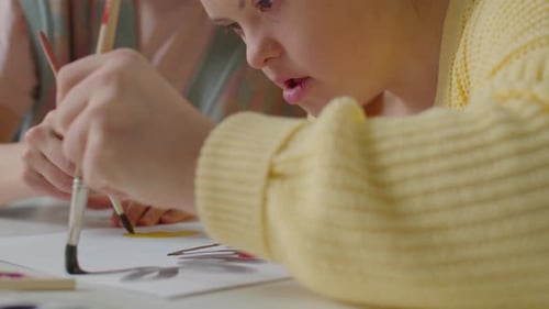 Young Woman Painting with Friend Indoors