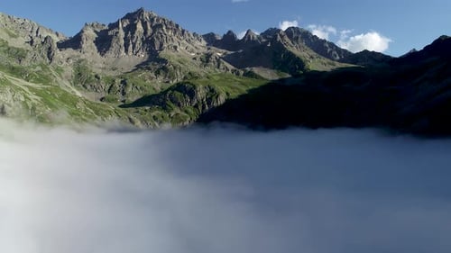 Aerial View of Rugged Mountains Emerging from Clouds