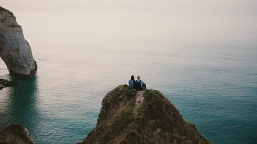 Drone Tilts Down Over Happy Romantic Couple Watching Sunset Ocean View