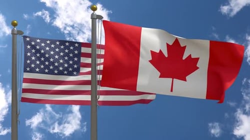 Canada and USA National Flags Waving on Flagpoles
