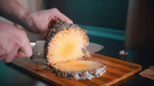 Pineapple Being Sliced on a Cutting Board