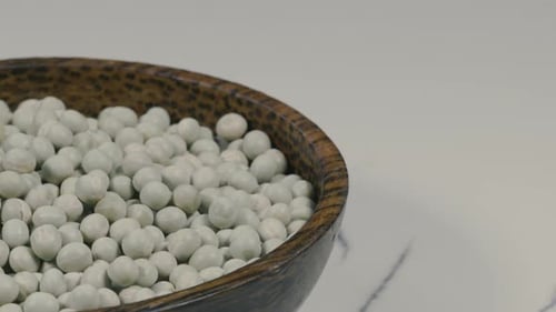 Wooden Bowl Filled with Green Peas on Counter