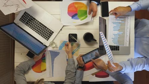 Male and Female Hands of Colleagues Work on Business Development Sitting at Table in Office