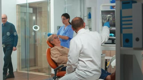 Estomatólogo señalando la pantalla digital explicando la radiografía