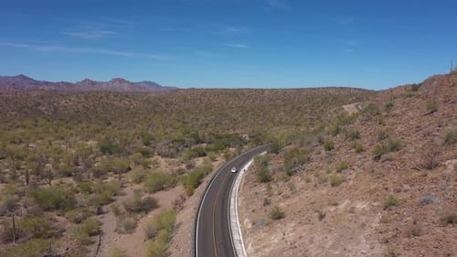 Kleines Auto fährt auf einer Wüstenautobahn in Mexiko