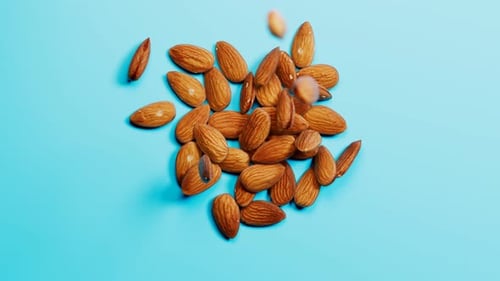 Falling Almonds Form Heart Shape on Blue Background