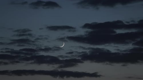 Neumond am Abendhimmel mit Wolken