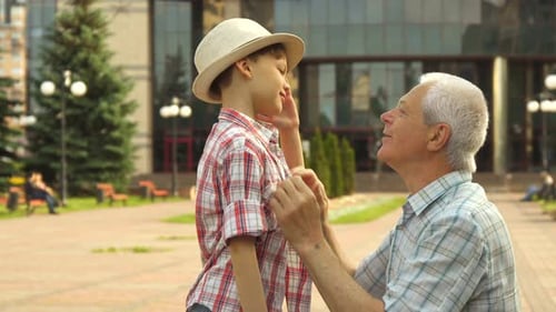 Loving Grandfather and Grandson Embrace in Urban Park