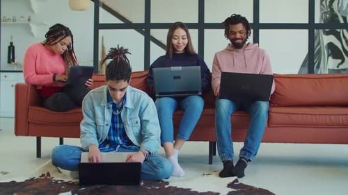Four Young Adults Working on Laptops Together
