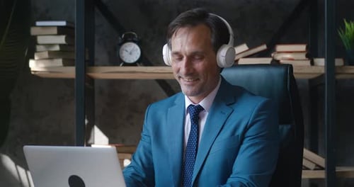 Smiling man working on laptop in home office
