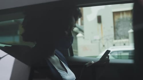 Mujer afroamericana con máscara facial en el coche