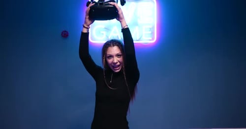 Young Woman Holding VR Headset in Urban Studio