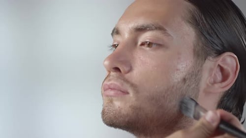 Makeup Artist Applying Makeup to Man's Face