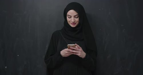 Woman in Headscarf Using Mobile Phone