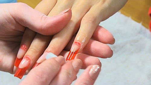 Red Artificial Nails Cleaned During Manicure Process