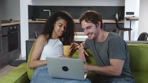 Young Couple Relaxing with Laptop on Couch