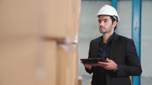 Factory Manager Using Tablet Computer in Warehouse or Factory