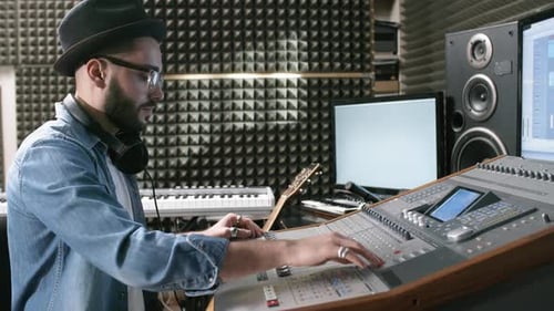 Male Sound Engineer Mixing Music in Recording Studio
