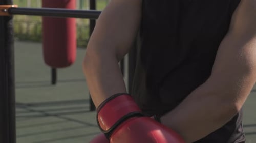 Muscular Man With Boxing Gloves on Urban Workout Area