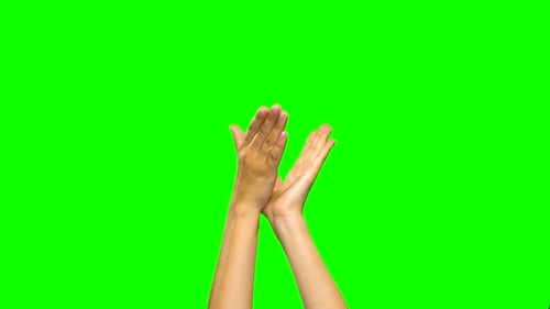 Las manos aplauden contra un fondo de pantalla verde. De cerca