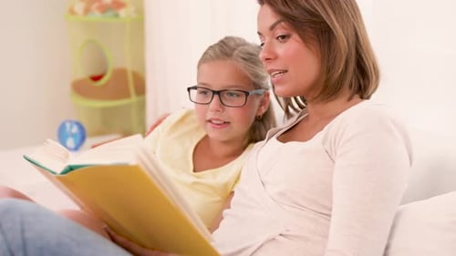 Child and Woman Read Book Together Indoors
