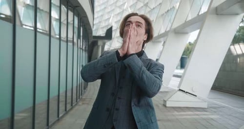 Cheerful man in suit celebrates success outdoors