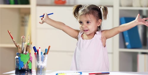 Happy Child Drawing with Markers Indoors