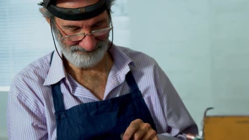 Goldsmith using digital tablet in workshop