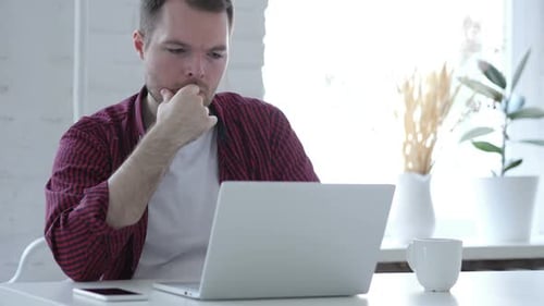 Young Man Working on Laptop in Modern Home