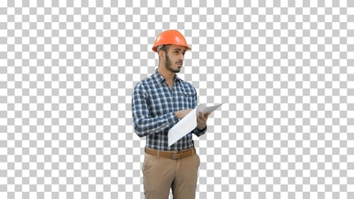 Junger Ingenieur im Helm überprüft Bauplan, Alpha Channel